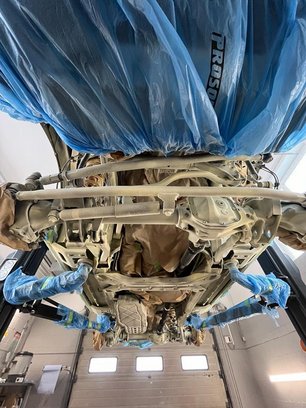 Unteransicht des Autos auf Hebebühne mit Abdeckung